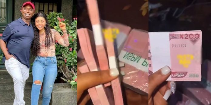 “I love it” – Actress Regina Daniels gushes as she shows off wads of new naira notes she received from husband, Ned Nwoko on movie set (Video)