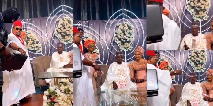 “Disrespectful!” – Netizens reacts to video of rich wedding guest spraying money on couple in an unusual manner (Video)