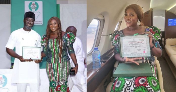 HOR member-elect, Odiasen Okojie dedicates his certificate of return to his wife, Mercy Johnson