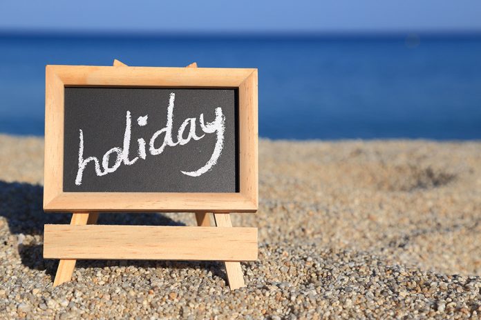 Blackboard with holiday text on the beach