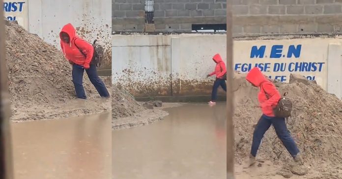 Lady gets stúck in mud, loses slipper while avoiding muddy water on street (WATCH)